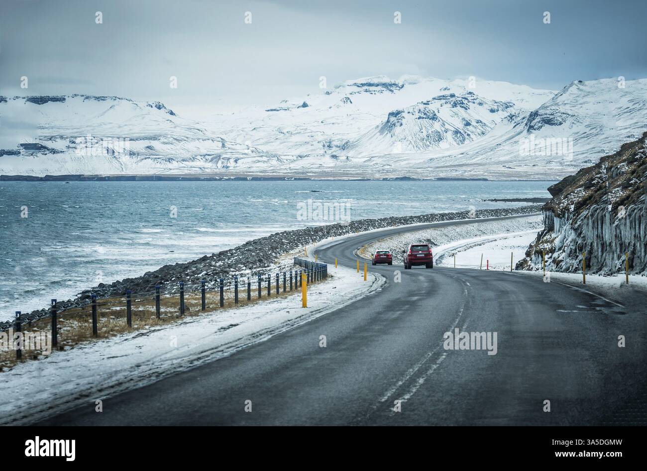 Modern car riding on asphalt countryside road towards magnificent snowy ...