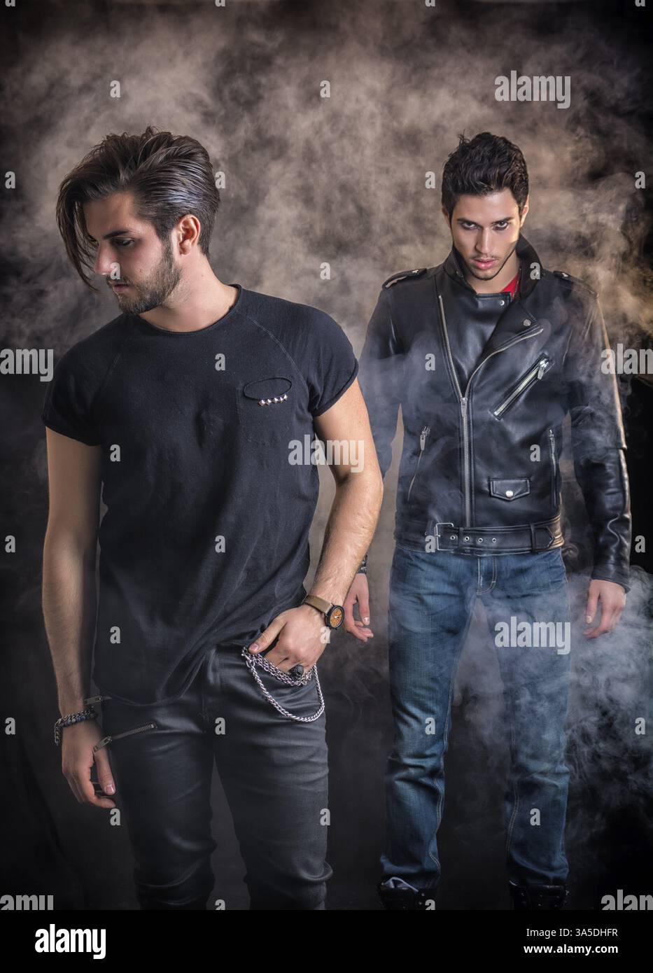 Two attractive young hard rock men posing in studio. Black background Stock Photo
