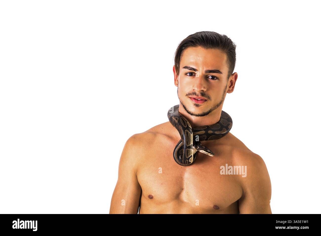 Three Quarter Length Portrait of Muscular Man with Shaved Head Standing in Studio with White Background, with Small Python Snake Wrapped Around Neck Stock Photo