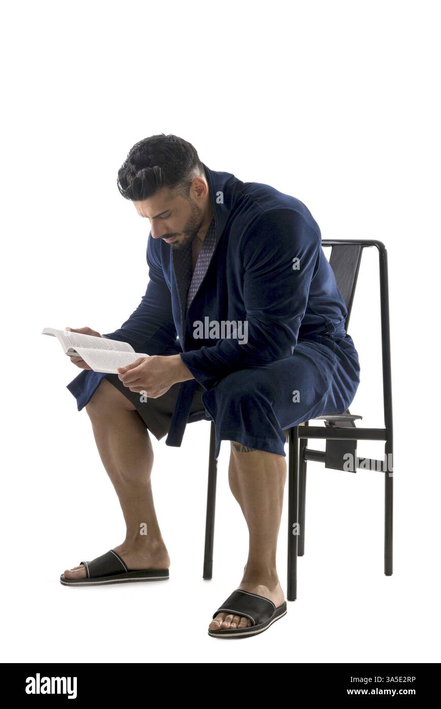 Handsome muscular male in bathrobe or nightrobe holding a book, isolated on white background Stock Photo