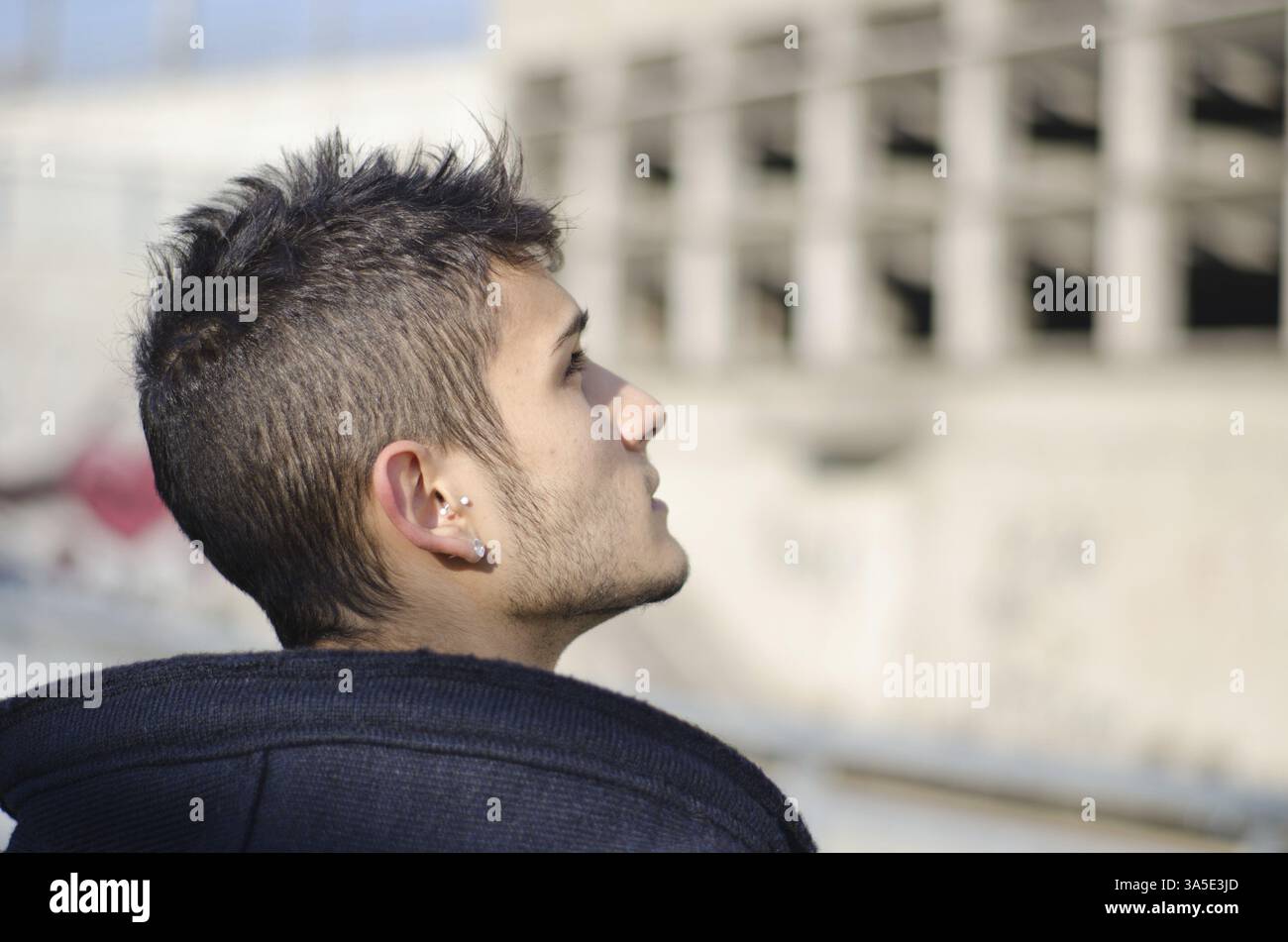 Attractive young man looking up, profile