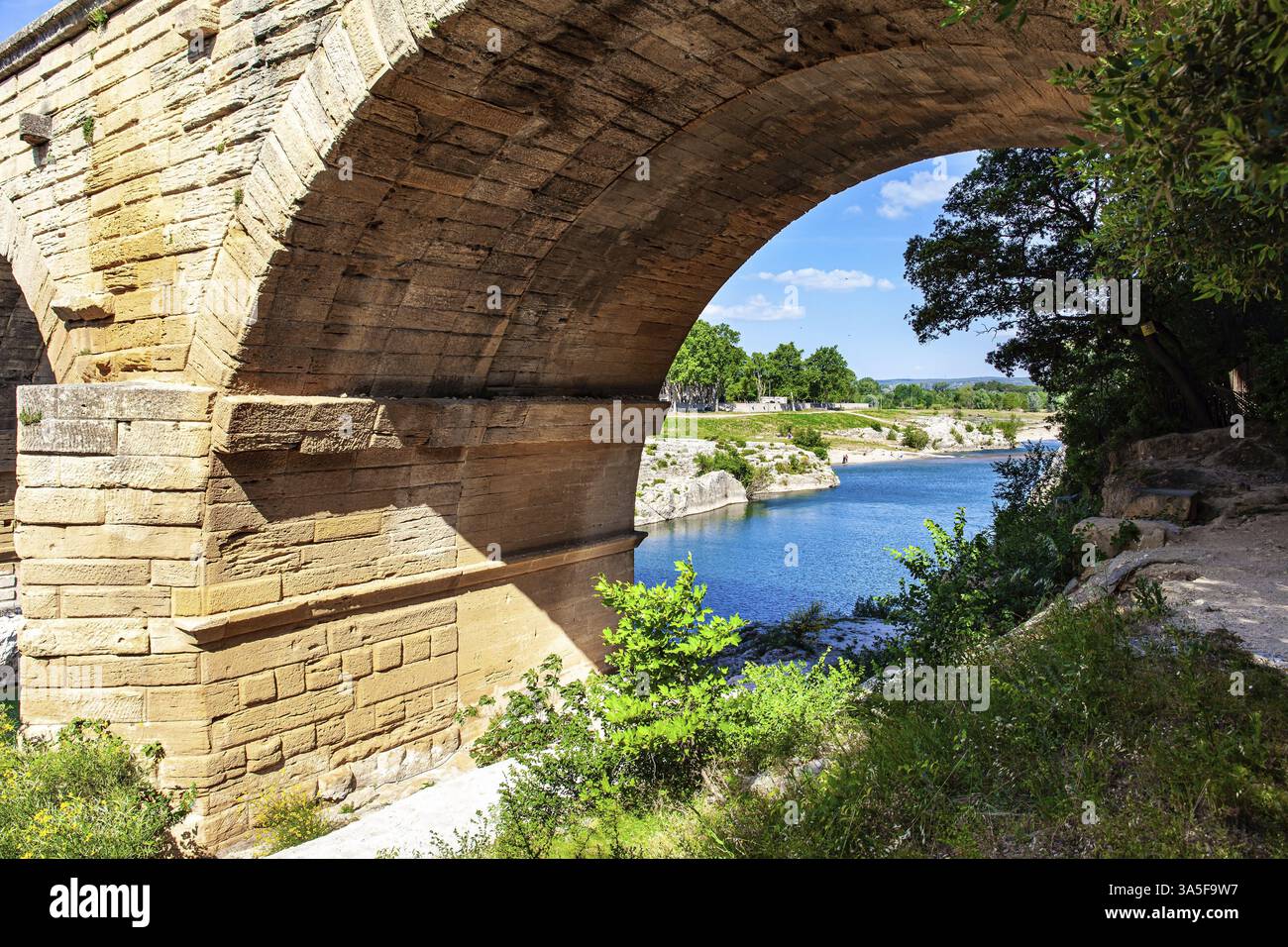 The perfectly preserved arch of the bridge - aqueduct. The Pont du Gard is the tallest Roman aqueduct. Interesting trip to France. The shallow Gardon Stock Photo