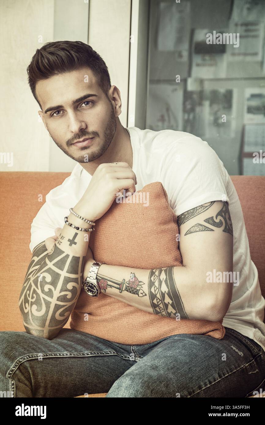 Handsome man sitting on couch looking at camera Stock Photo