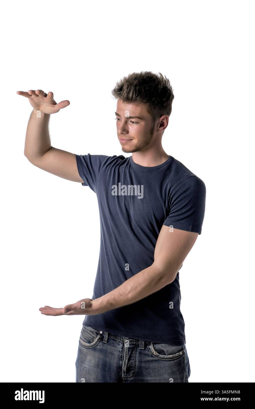 Handsome young man holding empty vertical space between hands for your product or text Stock Photo