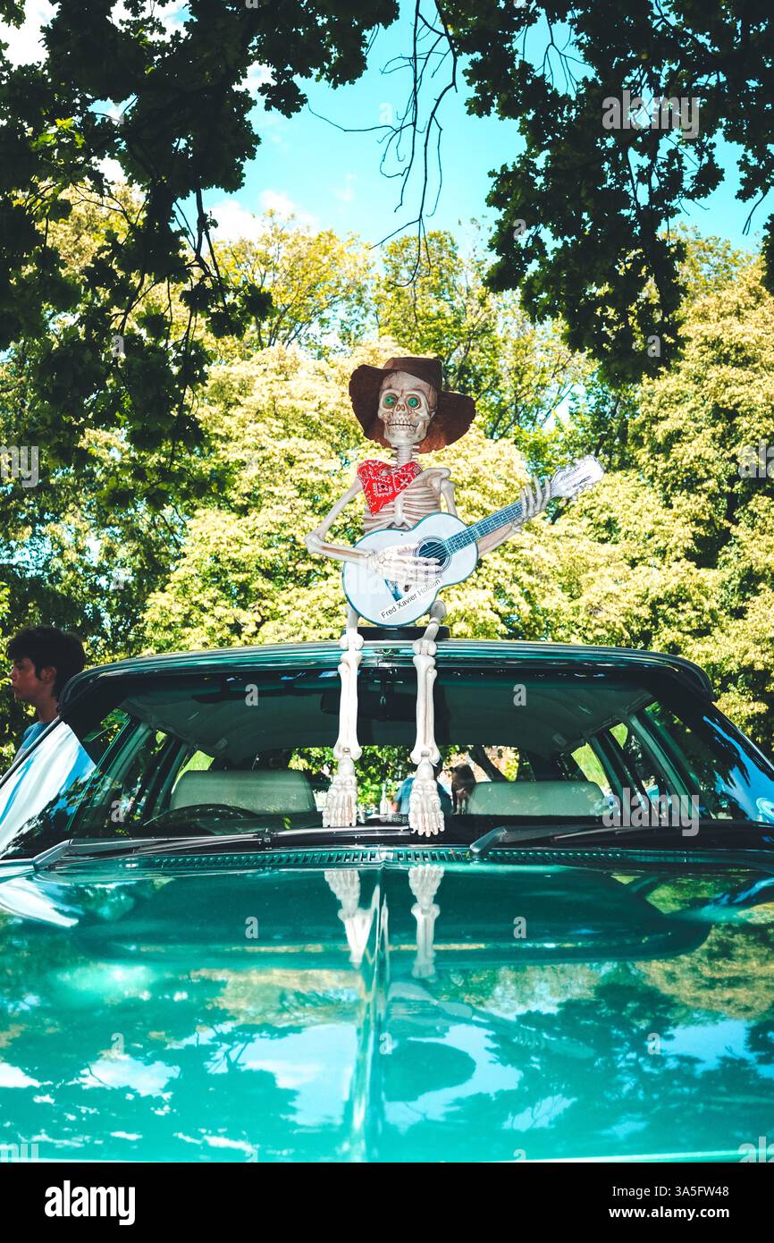 Day of the Dead meets joyful revelry: vintage cars, live music, and dancing souls under sunlit skies and papel picado hues. ? Stock Photo