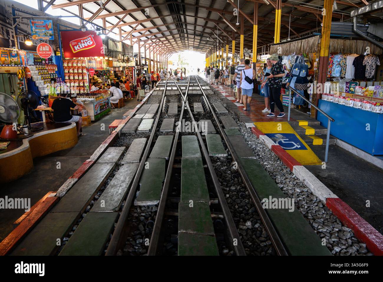 March 15, 2025, Mae Klong, Thailand: Rail lines at the Maeklong Railway station with cafes and street food stalls in Samut Songkhram province of Thailand. Mae Klong Railway Market is one of the largest fresh seafood markets in Thailand and spreads over the Maeklong Railway's track. Whenever a train approaches, the awnings and shop fronts are moved back from the rails, to be replaced once the train has passed. The spectacle has become a major tourist attraction with cafes and stalls to cater for the weekend visitors. (Credit Image: © John Wreford/SOPA Images via ZUMA Press Wire) EDITORIAL USAGE Stock Photo