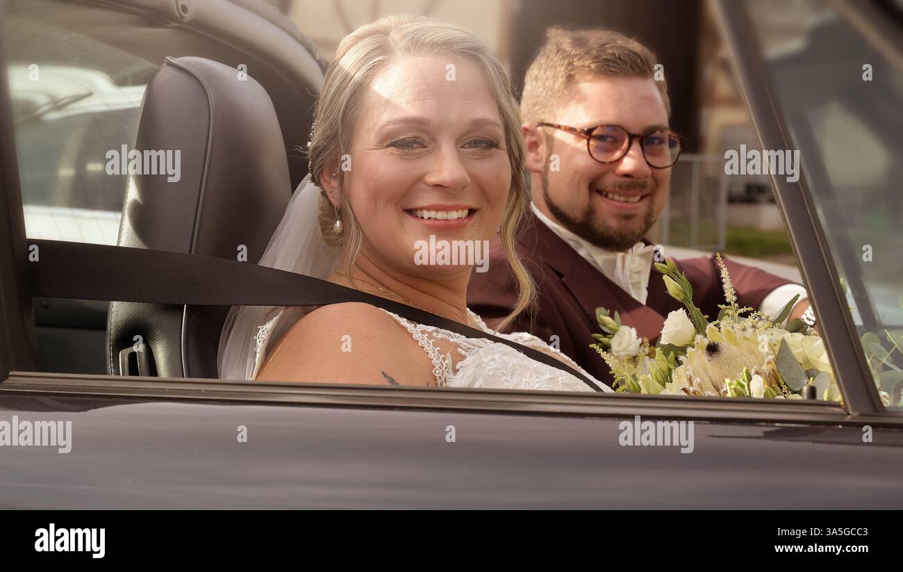Bride and groom, couple in Cabrio car on wedding day. Portrait of a wedding couple bride and groom on their wedding day, the couple embrace. Stock Photo