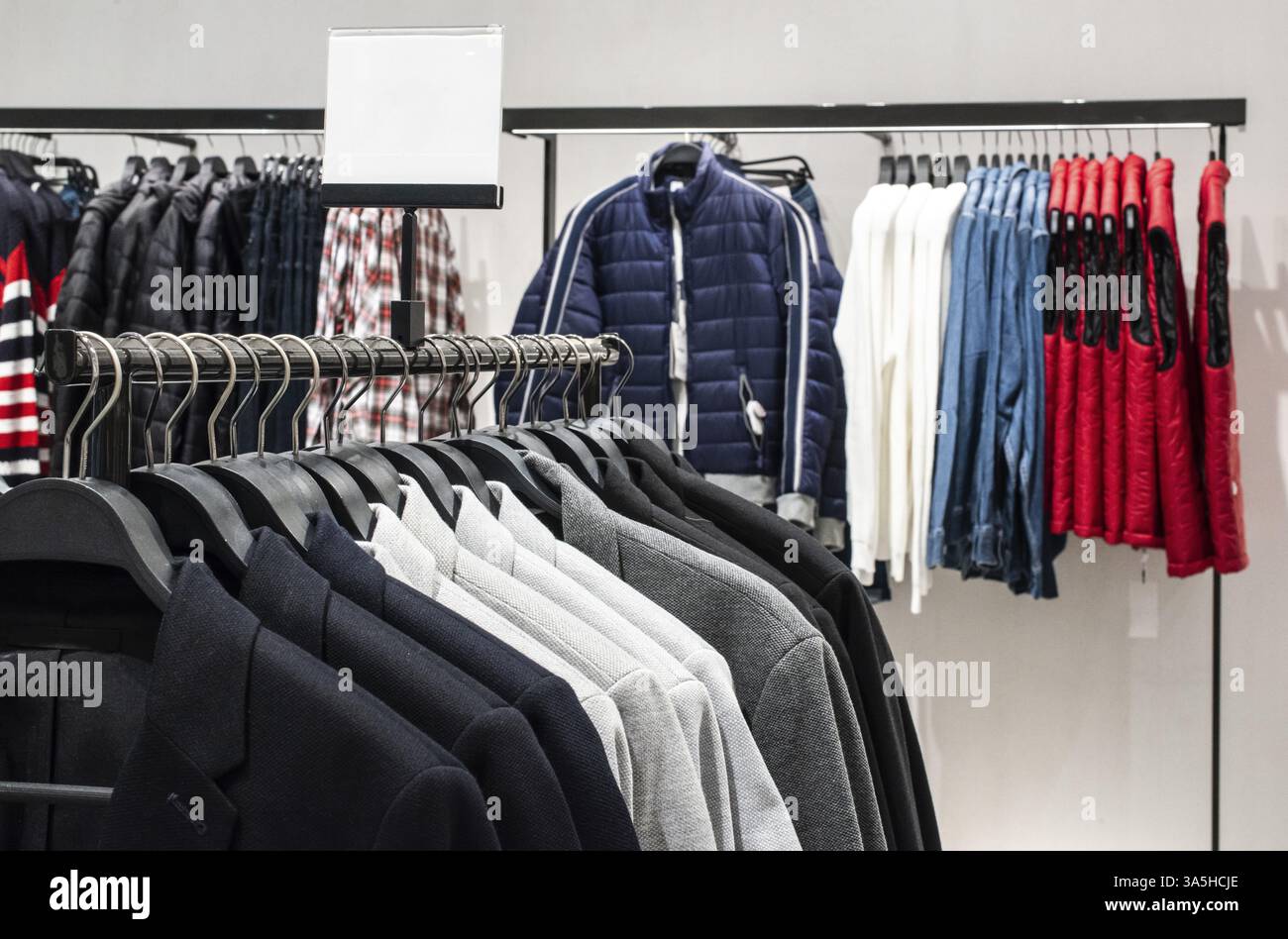Blouses and jeans on shelf in fashion clothing store. Casual clothes in shop. Commercial and fashion concept Stock Photo