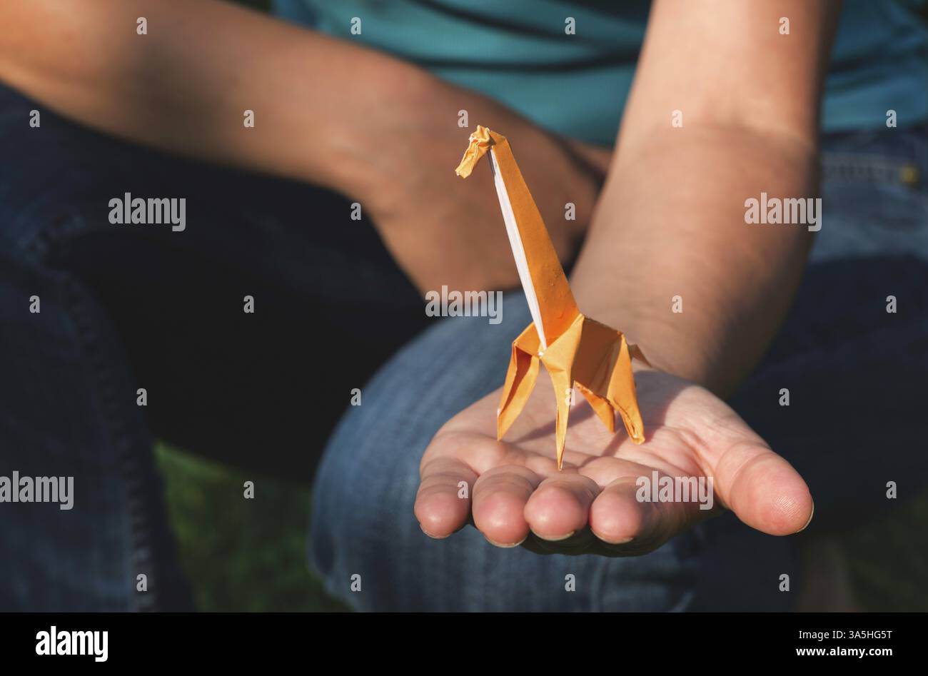 Origami orange color giraffe on hand Stock Photo