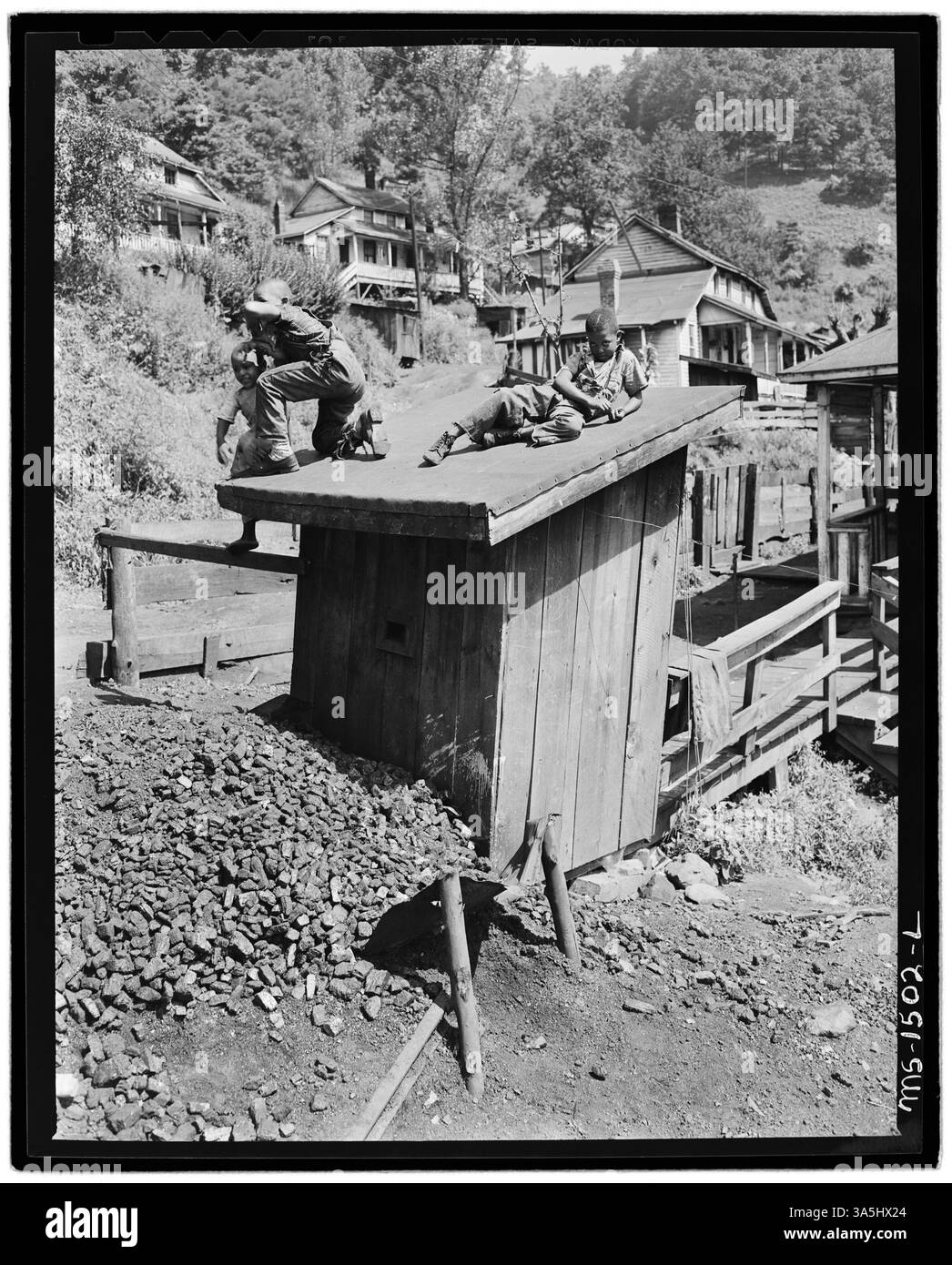 Children play on a privy in a coal mining camp due to a lack of safe play areas, reflecting the poor living conditions of the time. This image is from the Gilliam Coal and Coke Company in Gilliam, McDowell County, West Virginia. Stock Photo