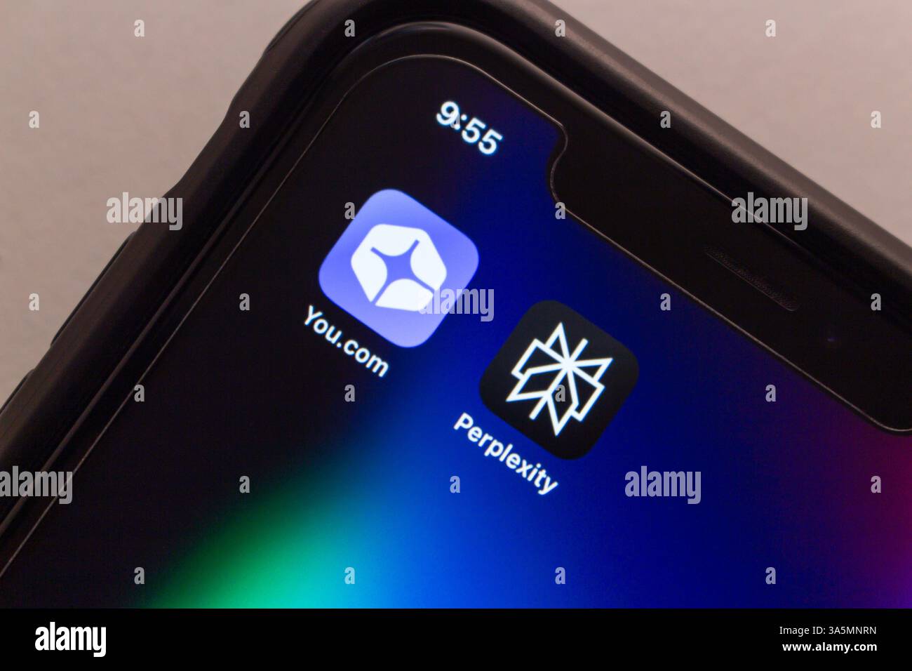 You.com and Perplexity app icons are displayed side by side on an iPhone, representing two notable contenders in the emerging AI search engine arena. Stock Photo