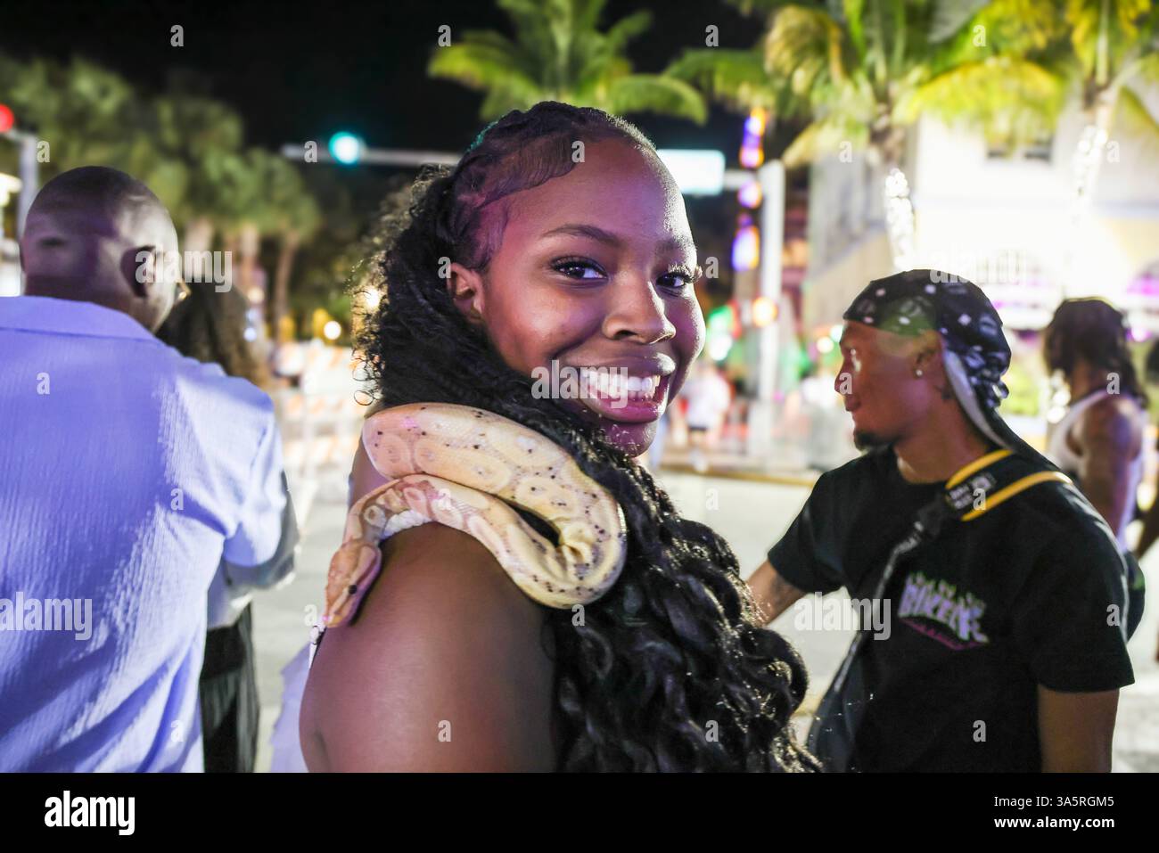 Miami Beach, Fl, USA. 22nd Mar, 2025. A woman smiles as she holds a snake around her neck during Spring Break in Miami Beach, Florida (Credit Image: © Amy Katz/ZUMA Press Wire) EDITORIAL USAGE ONLY! Not for Commercial USAGE! Stock Photo
