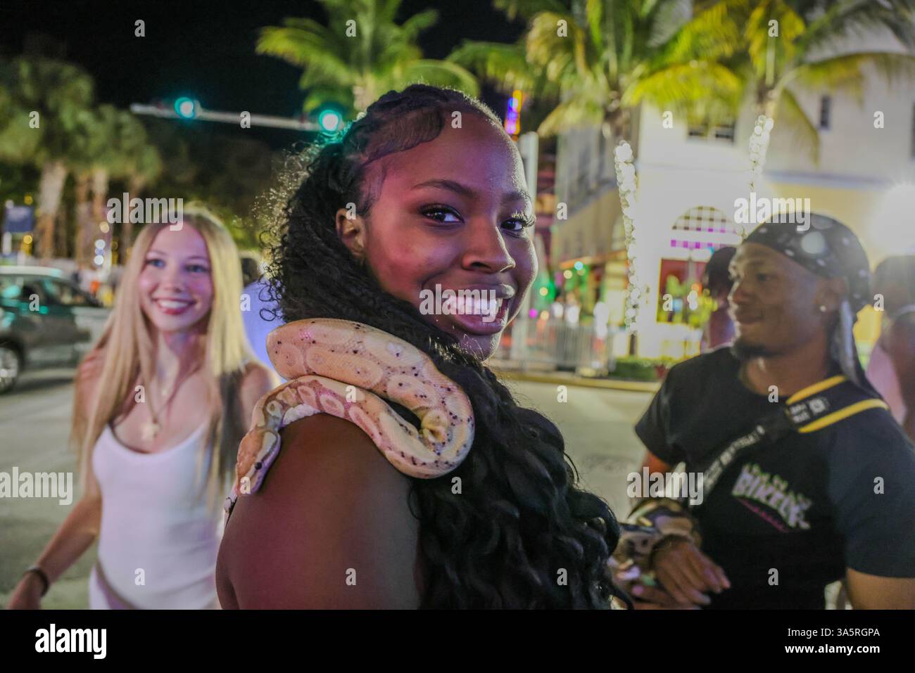Miami Beach, Fl, USA. 22nd Mar, 2025. A woman smiles as she holds a snake around her neck during Spring Break in Miami Beach, Florida (Credit Image: © Amy Katz/ZUMA Press Wire) EDITORIAL USAGE ONLY! Not for Commercial USAGE! Stock Photo