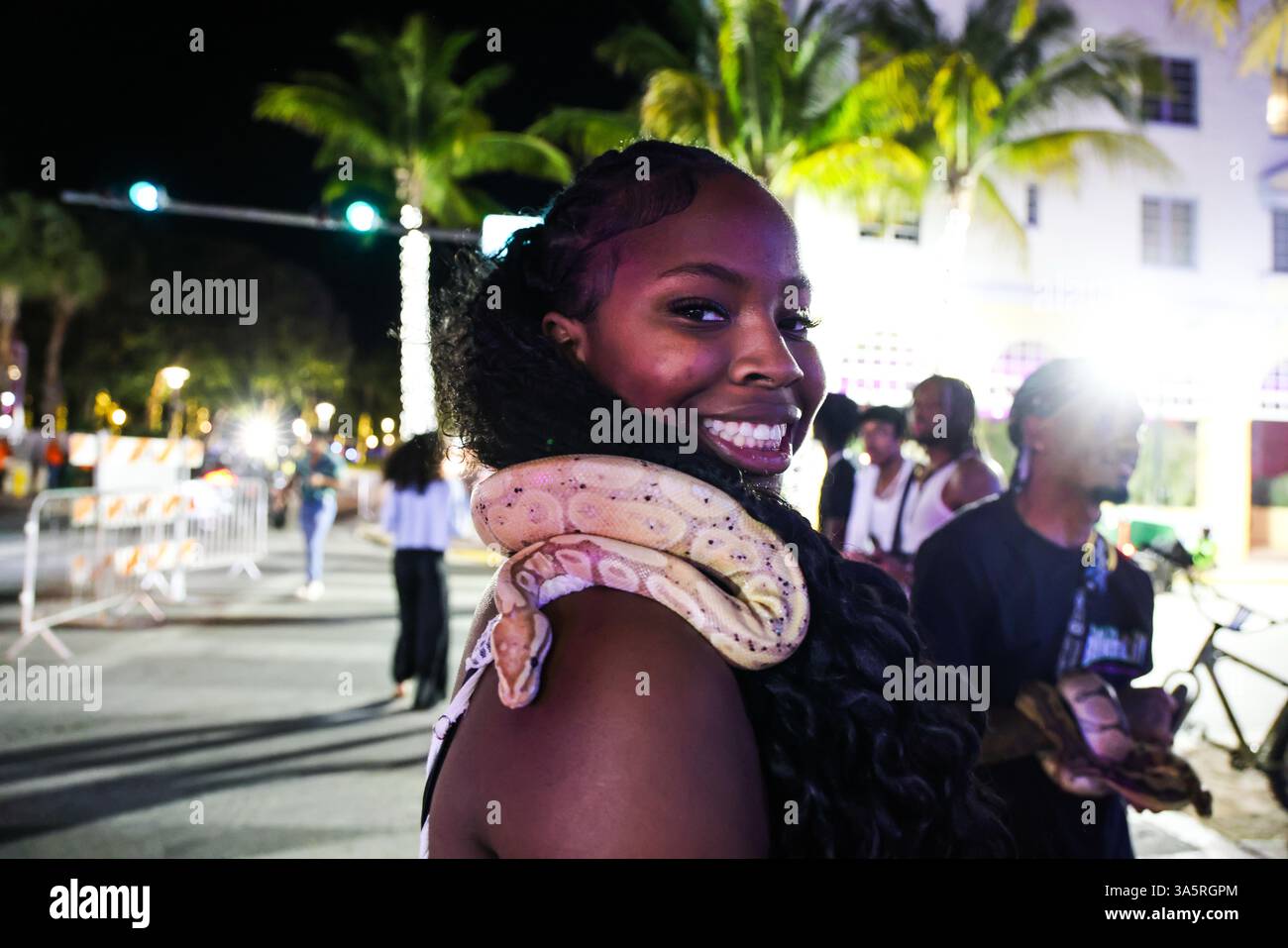 Miami Beach, Fl, USA. 22nd Mar, 2025. A woman smiles as she holds a snake around her neck during Spring Break in Miami Beach, Florida (Credit Image: © Amy Katz/ZUMA Press Wire) EDITORIAL USAGE ONLY! Not for Commercial USAGE! Stock Photo