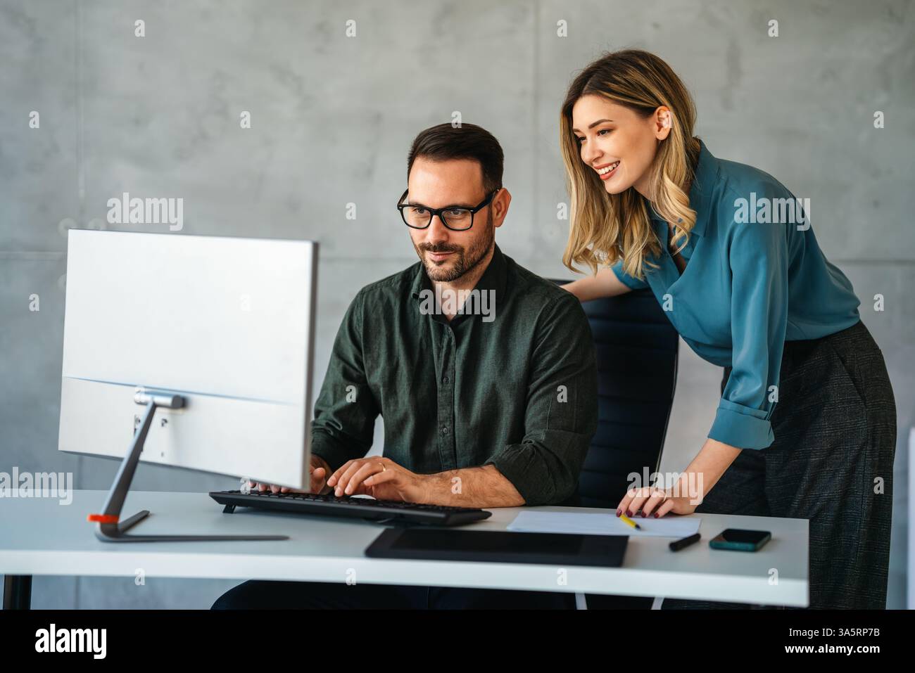 Business professionals collaborating on a project in a modern office. Team of coworkers sharing idea Stock Photo