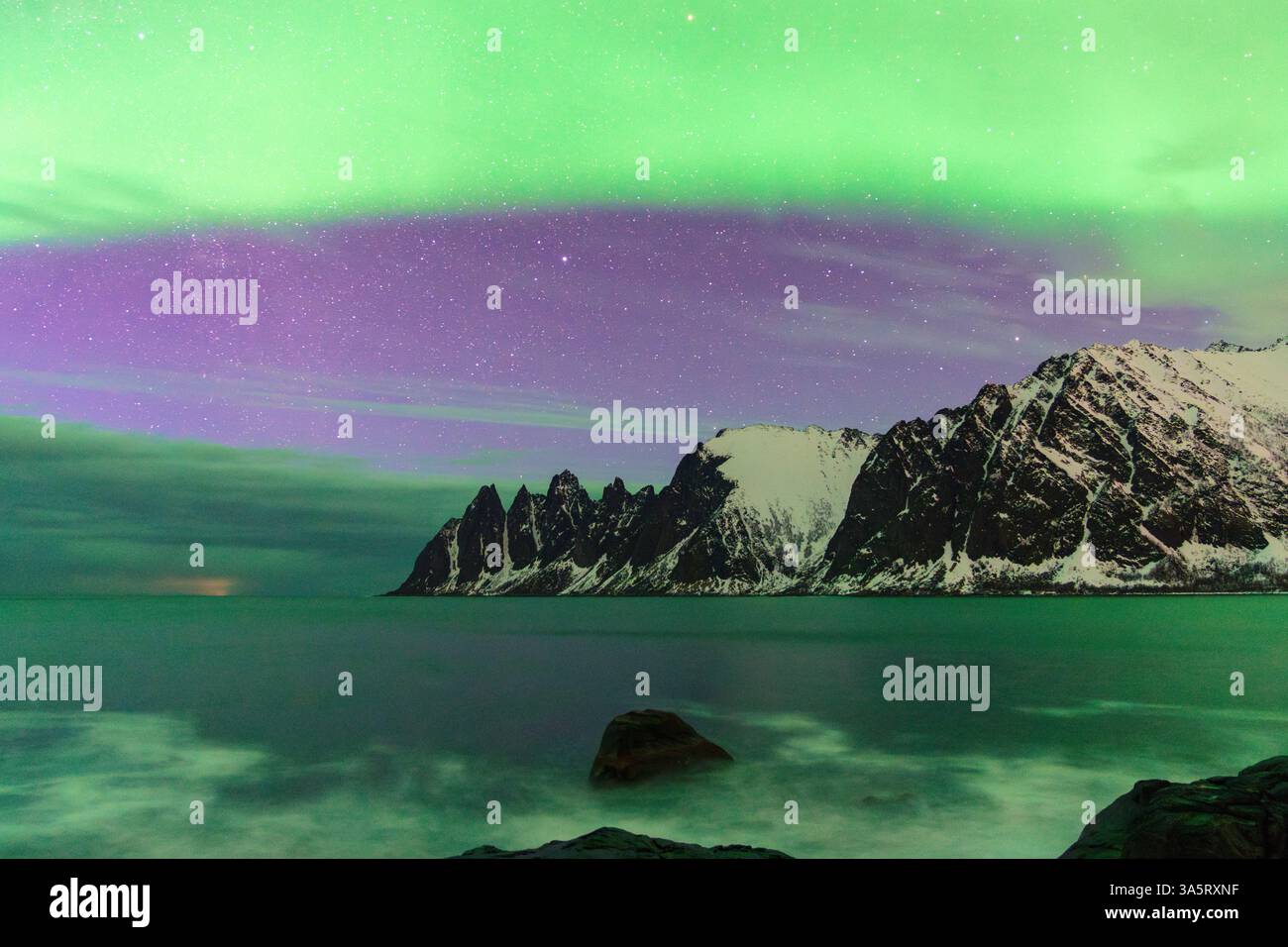 Bright Northern Lights over snowy mountains and sea Stock Photo - Alamy