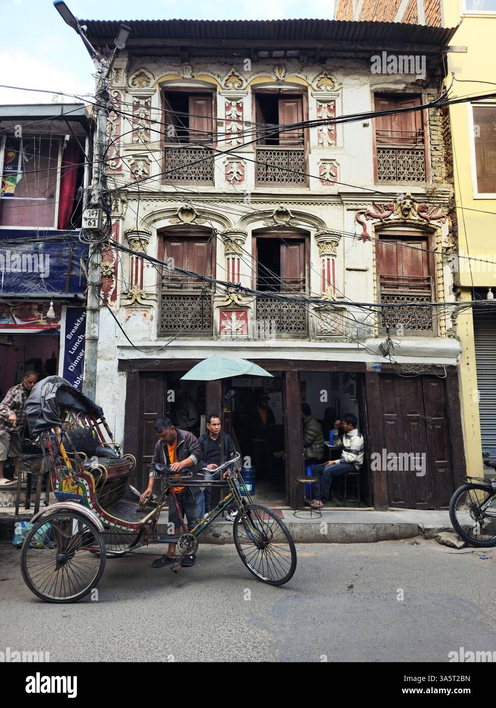 A bicycle rickshaw under an old beautiful building in the Thamel neighborhood in Kathmandu, Nepal. - Smartphone Captured Stock Image