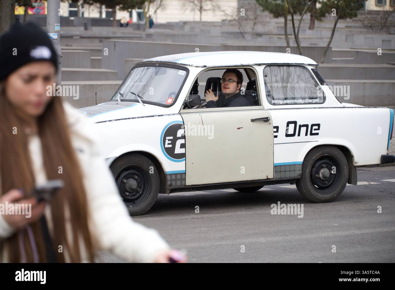 Berlin, Germany. February 23, 2025. A person walks by a vintage car Trabant 601. Stock Photo