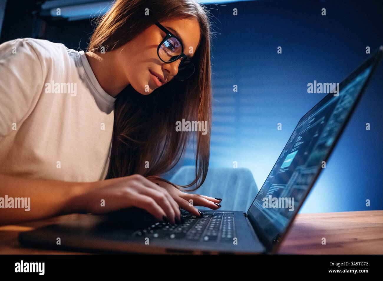 Female programmer, IT worker is sitting by the laptop. Stock Photo