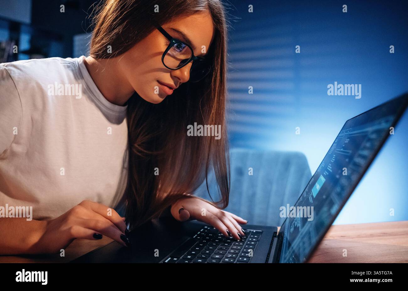 Female programmer, IT worker is sitting by the laptop. Stock Photo