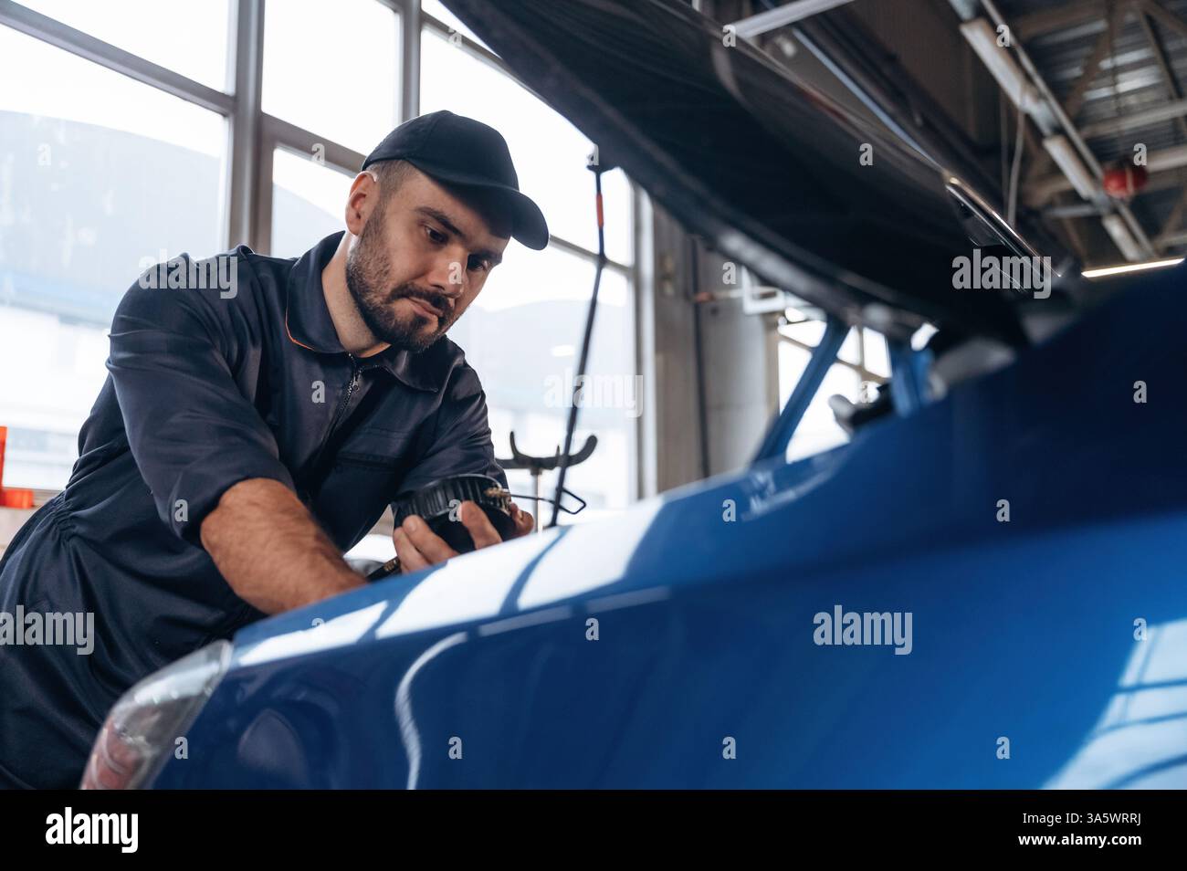 Workcomp Mechanic Focused at work. Mechanic is in a car service station Stock Photo - Alamy