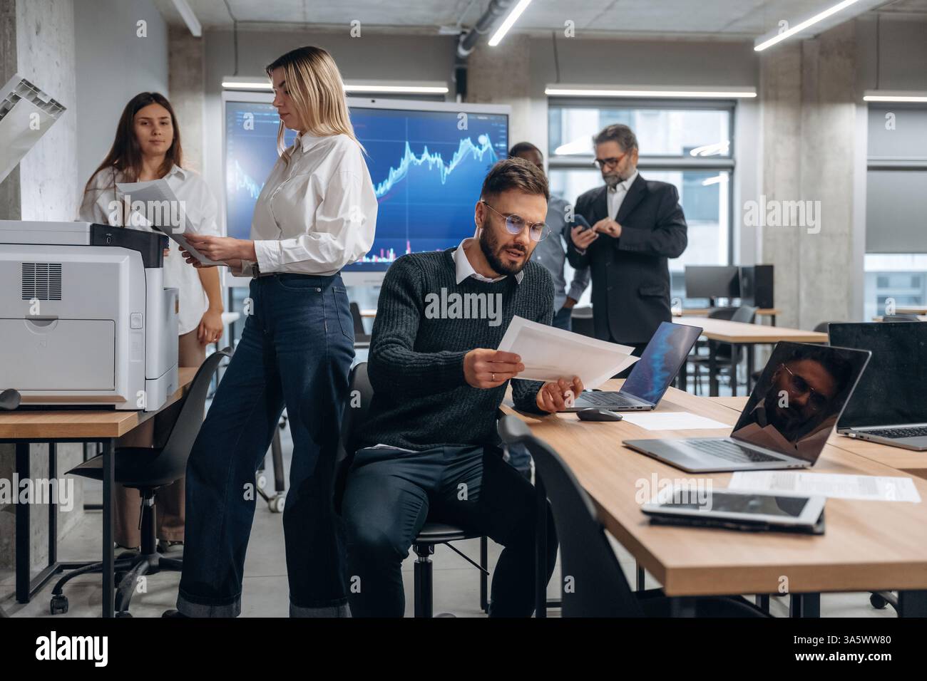 Using printer. Group of office workers are indoors together. Stock Photo