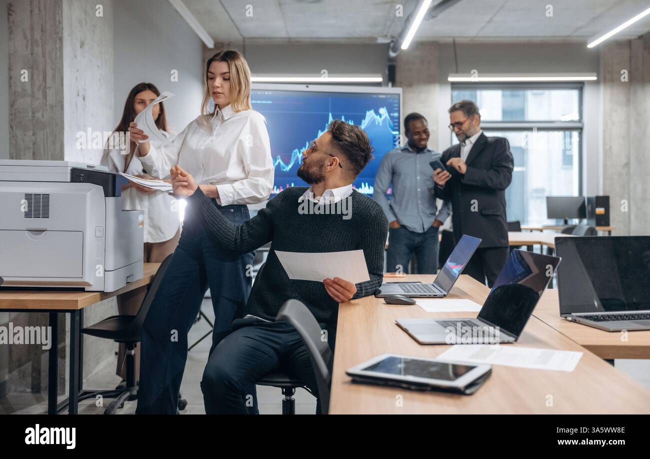 Using printer. Group of office workers are indoors together. Stock Photo