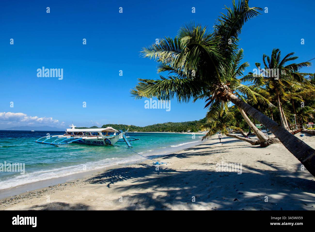 A man walks along pIcturesque Talipanan Beach, in Puerto Galera on ...
