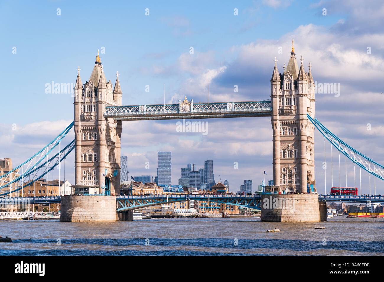 London tower bridge, with a red bus passing by, Canary Wharf skyline in the distance Stock Photo