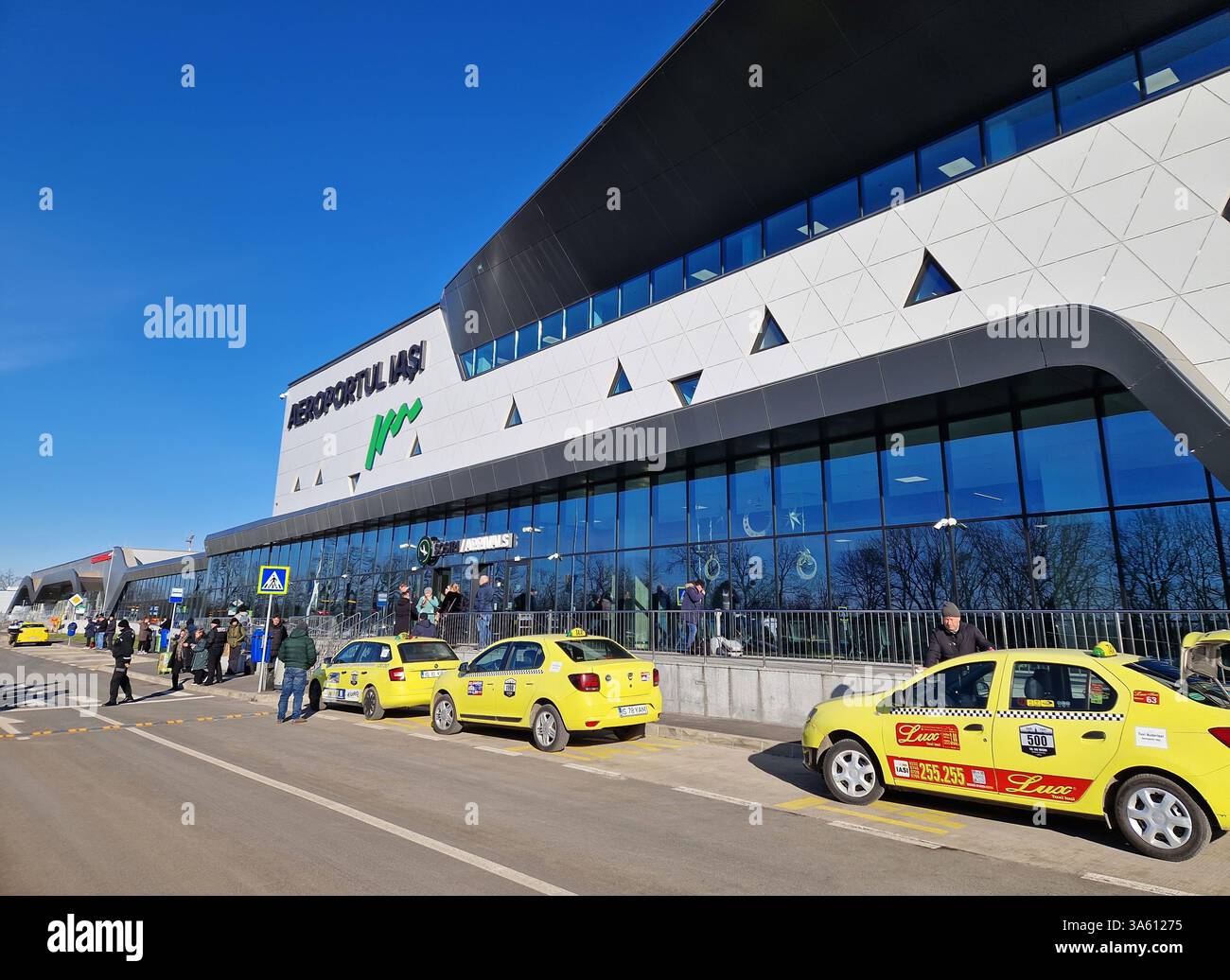 IASI, ROMANIA - JANUARY 5, 2025 Modern Iasi airport outdoors view of the new terminal T4. Yellow taxis are parked in front - Smartphone Captured Stock Image