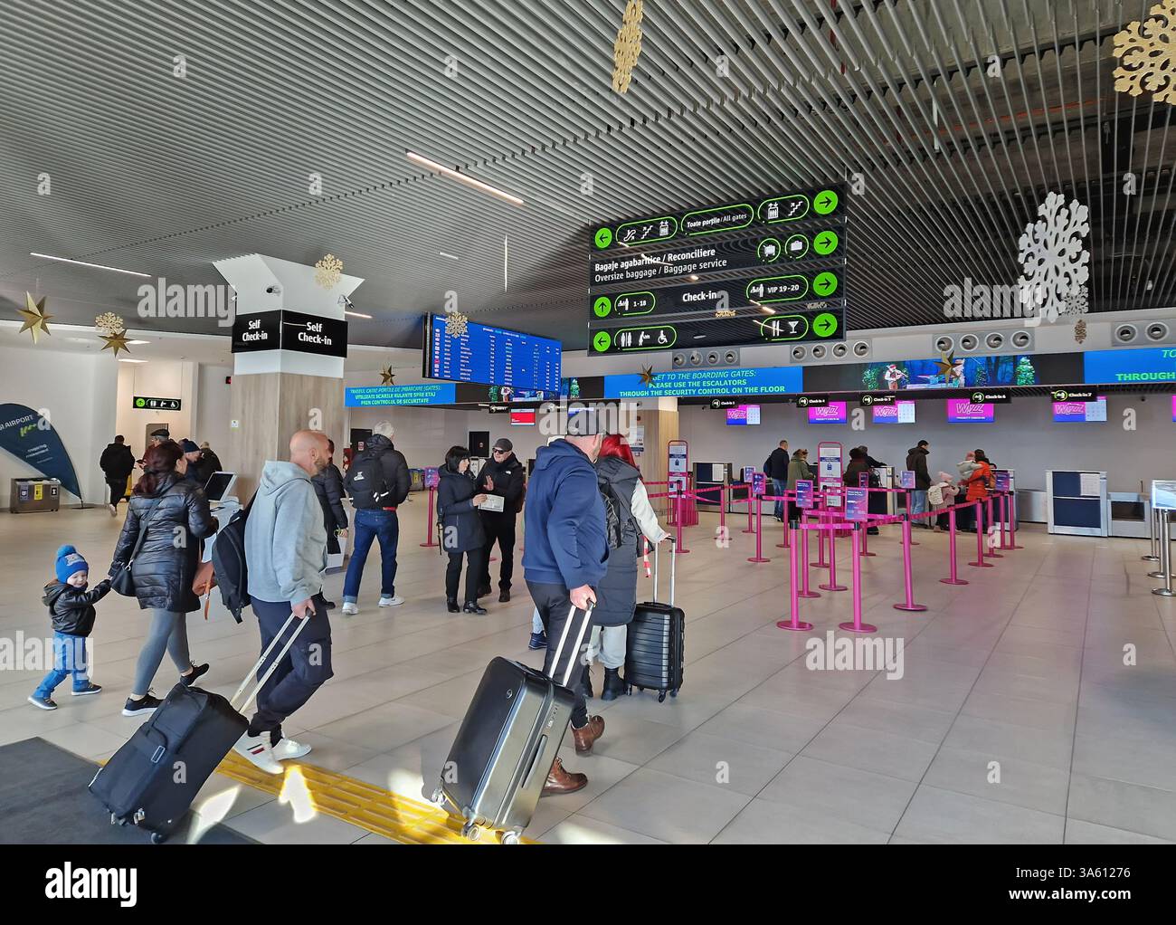 IASI, ROMANIA - JANUARY 5, 2025 Modern Iasi airport indoors view of the new terminal T4 with passengers pulling luggage, heading check-in kiosks and b - Smartphone Captured Stock Image