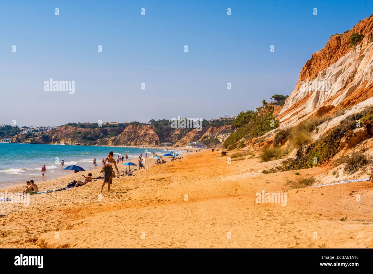 Beachgoers at Red sandstone cliffs of Praia da Falesia, Albufeira district, southern, portugal Stock Photo