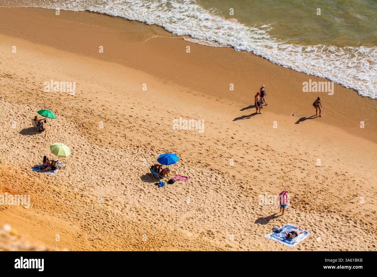 Beachgoers at Red sandstone cliffs of Praia da Falesia, Albufeira district, southern, portugal Stock Photo