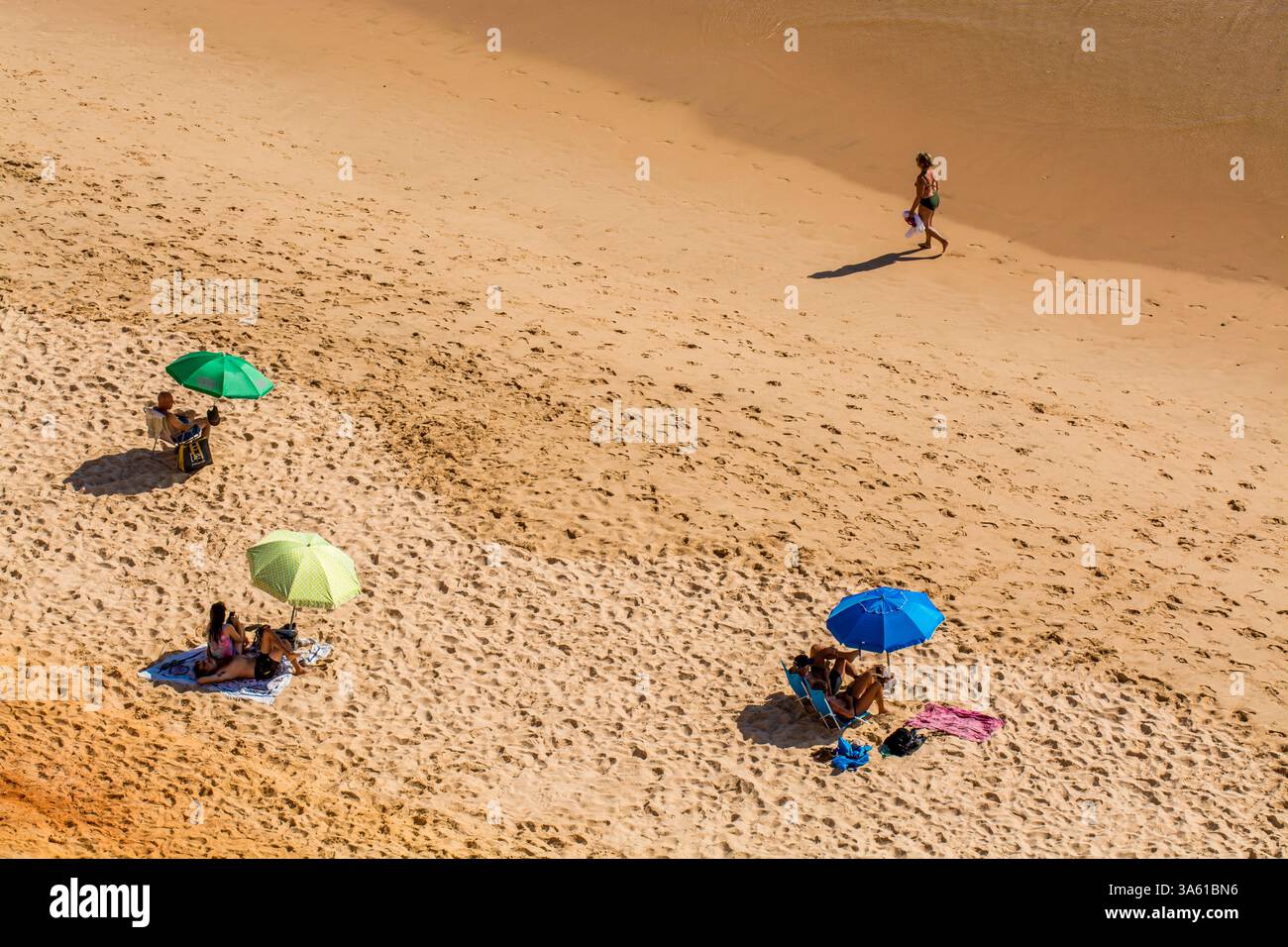 Beachgoers at Red sandstone cliffs of Praia da Falesia, Albufeira district, southern, portugal Stock Photo