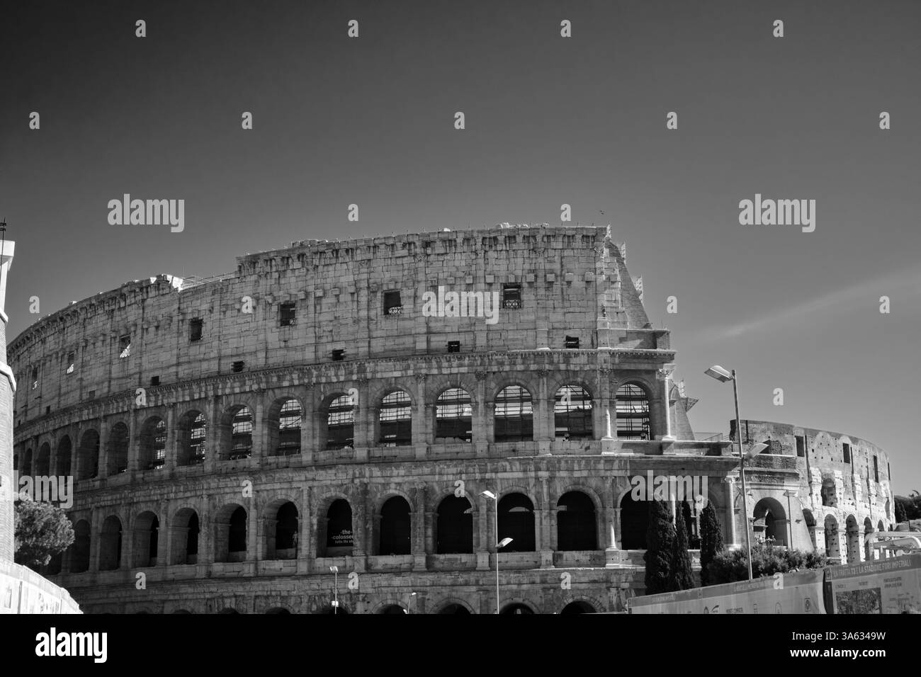 The Colosseum stands in silence, its ancient stones bathed in shadows, a timeless symbol of Rome's glorious past captured in black and white Stock Photo