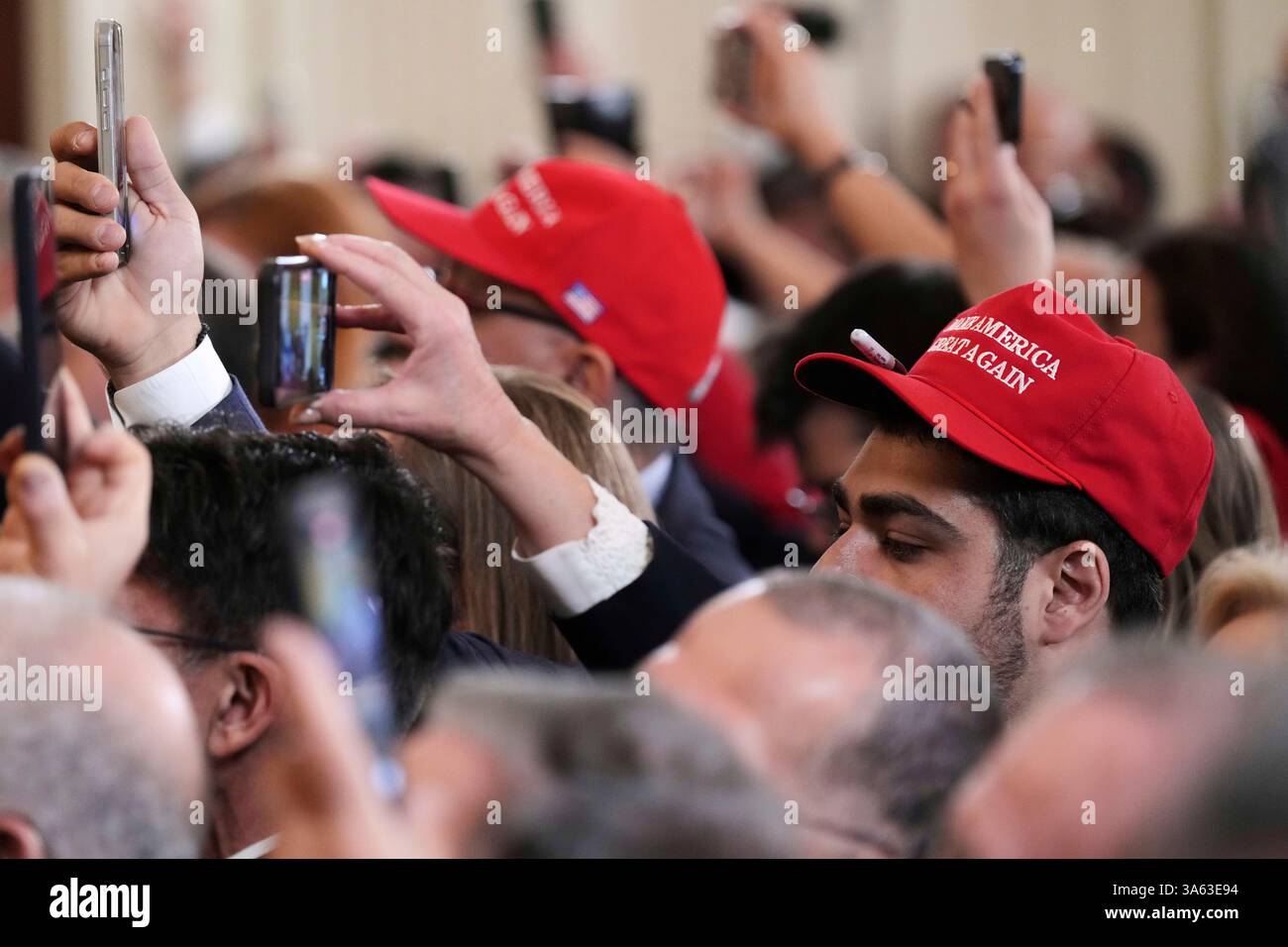 Attendees watch and record with their phones as President Donald Trump ...