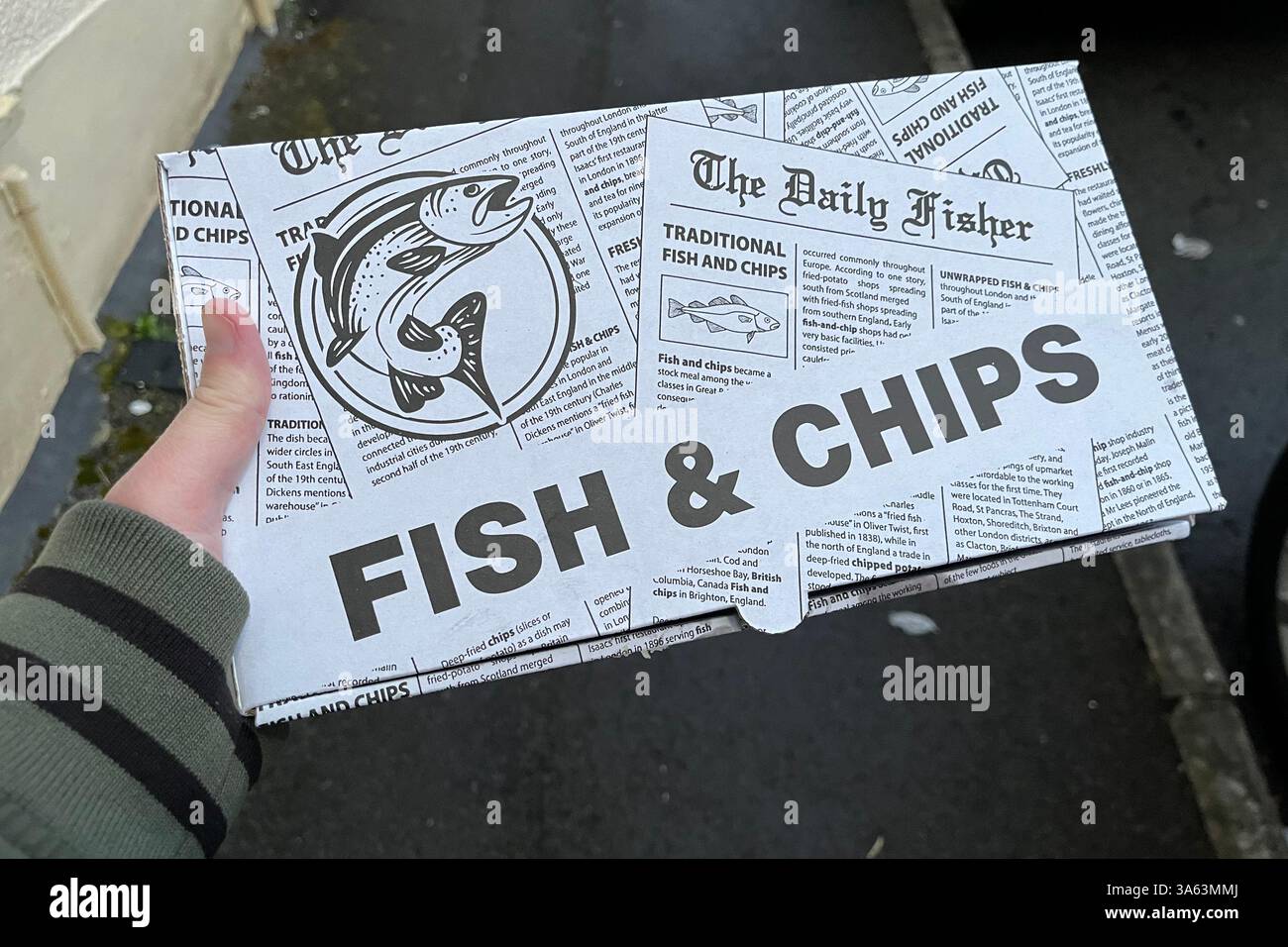 Fish & Chips Takeaway Box designed to look like an old newspaper, which historically Fish & Chips used to be wrapped in. 21st March 2025. - Smartphone Captured Stock Image