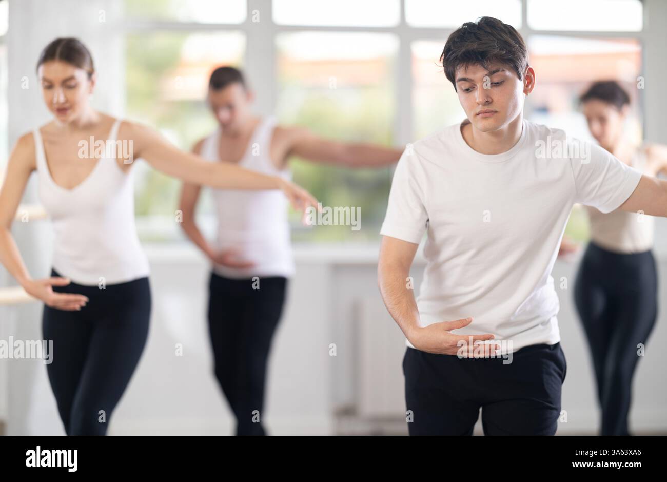 Young guy participating in group ballet class in choreography studio Stock Photo