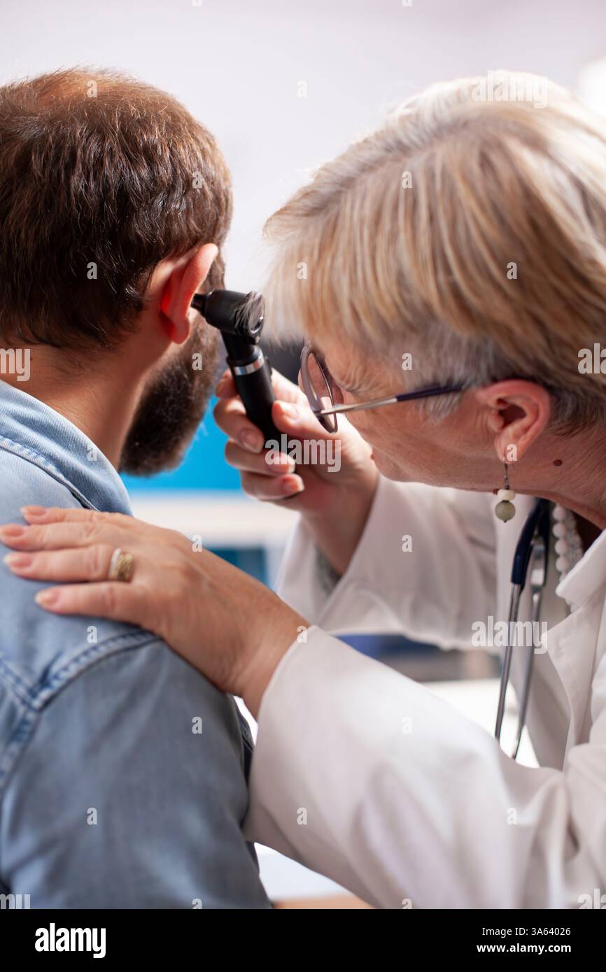 Doctor performing ear examination otoscope hi-res stock photography and ...