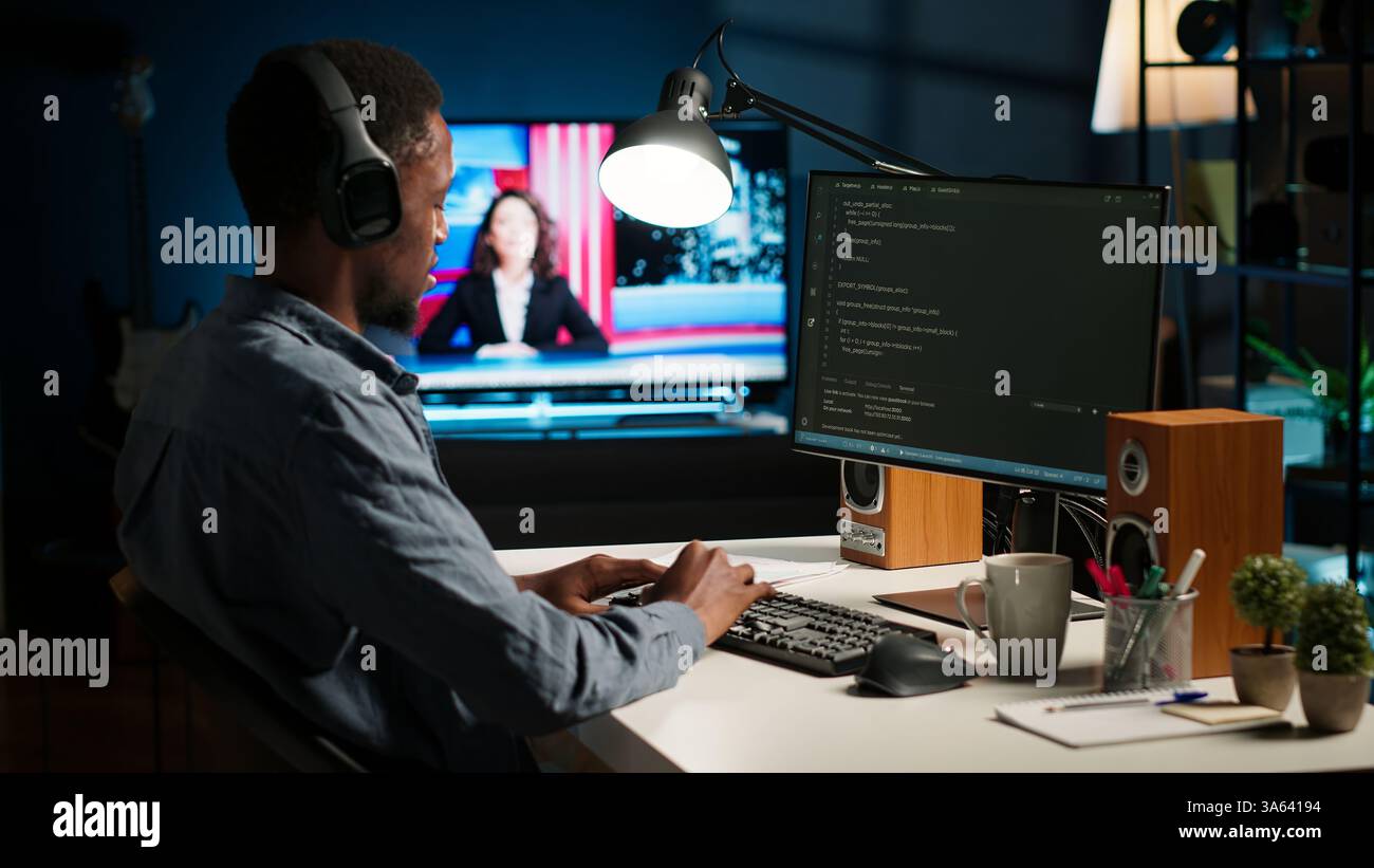 African american male programmer working on cloud computing with an algorithm, writing code for optimization on terminal window. IT specialist inserts html code, server security. Camera B. Stock Photo