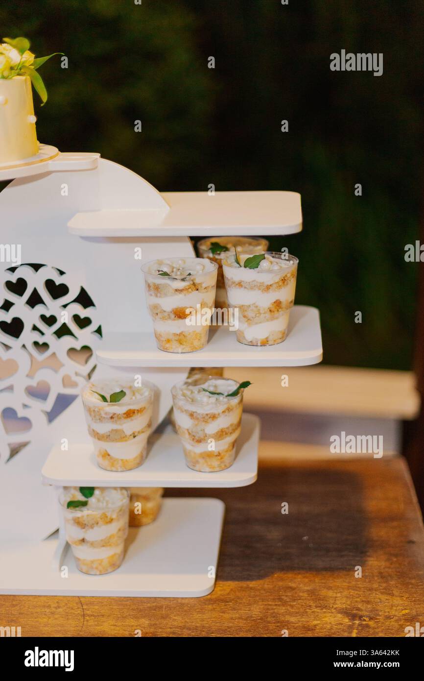 Appetizing looks more cakes in cups on a white stand at the holiday Stock Photo