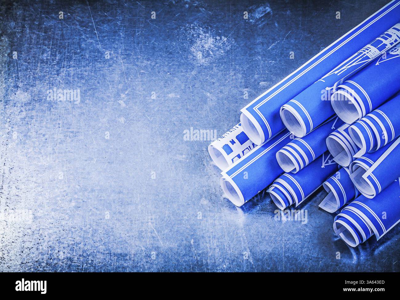 Blue rolled construction plans on metallic background copy space ...