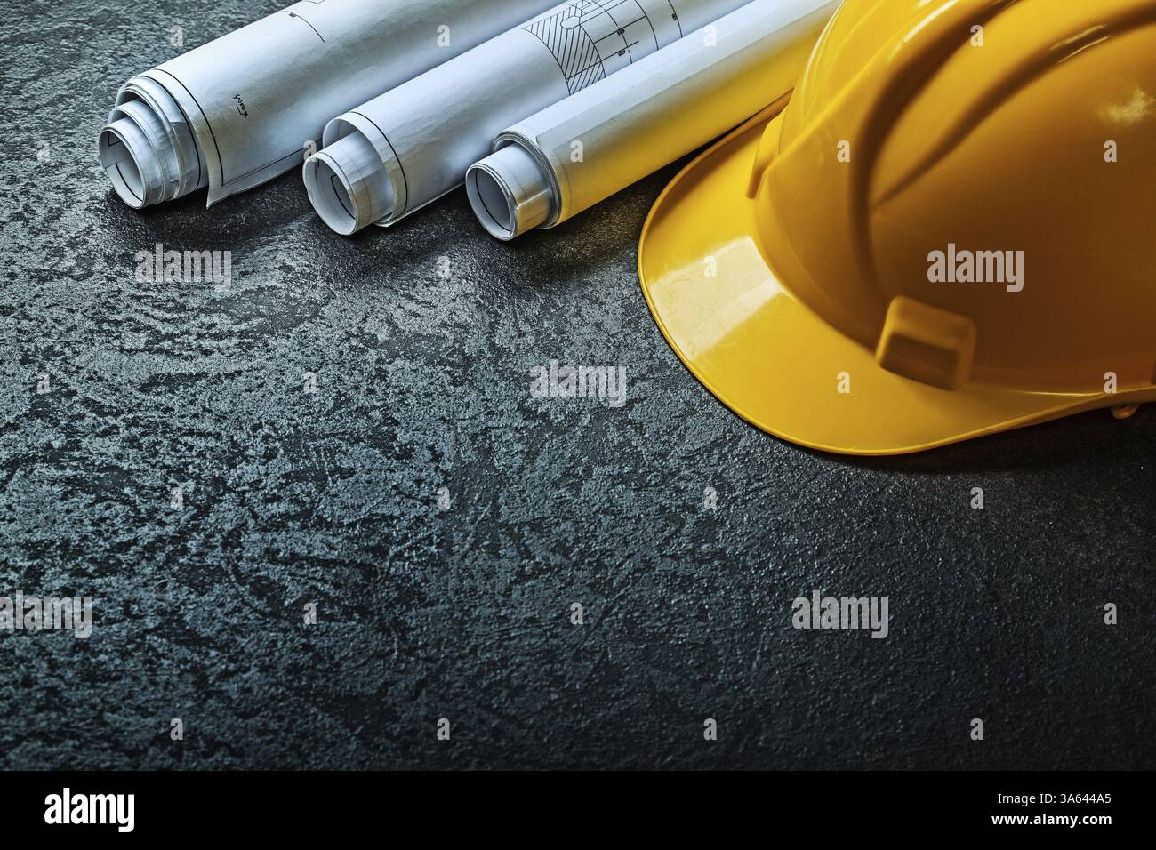 Yellow helmet and three rolled blueprints Stock Photo - Alamy