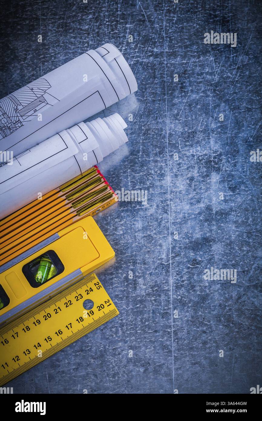 Blueprints yellow ruler construction level and wooden meter on metallic ...