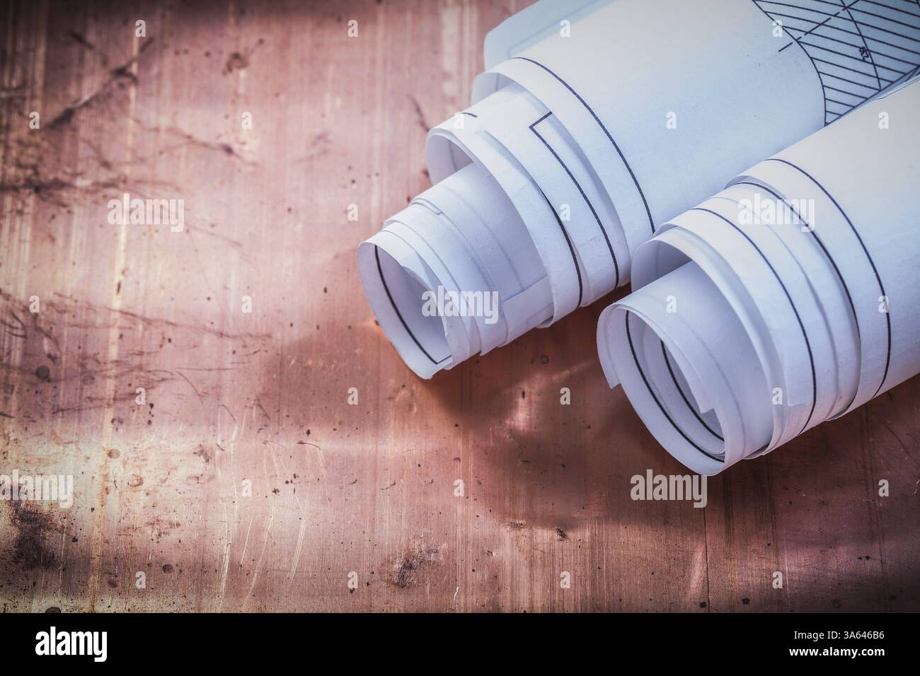 Rolled blueprints on brazen background construction concept Stock Photo