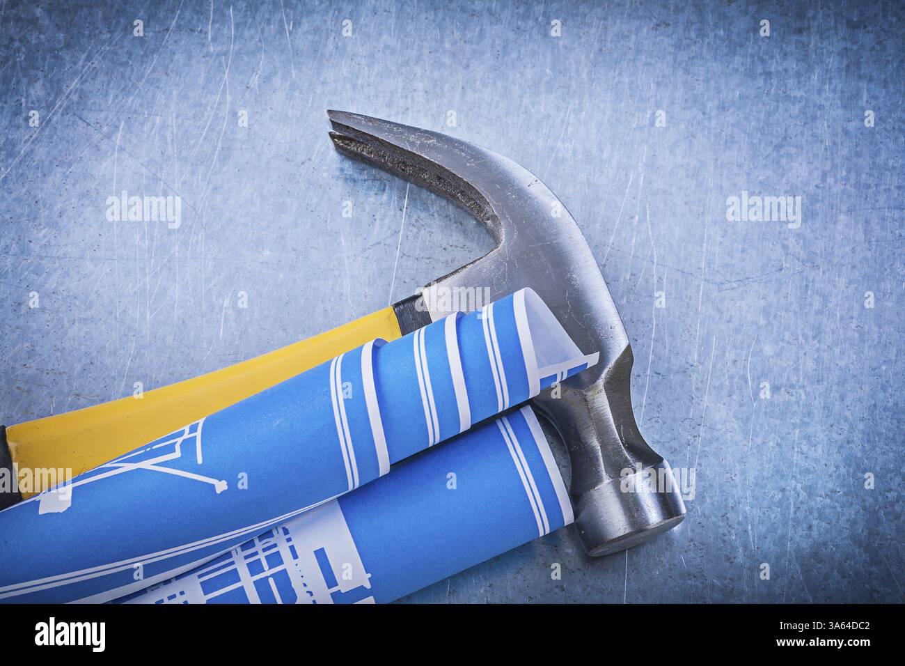 Blue rolled blueprints claw hammer on metallic background construction ...