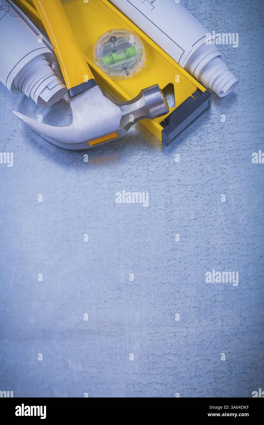 Rolled blueprints construction level claw hammer on metallic background ...