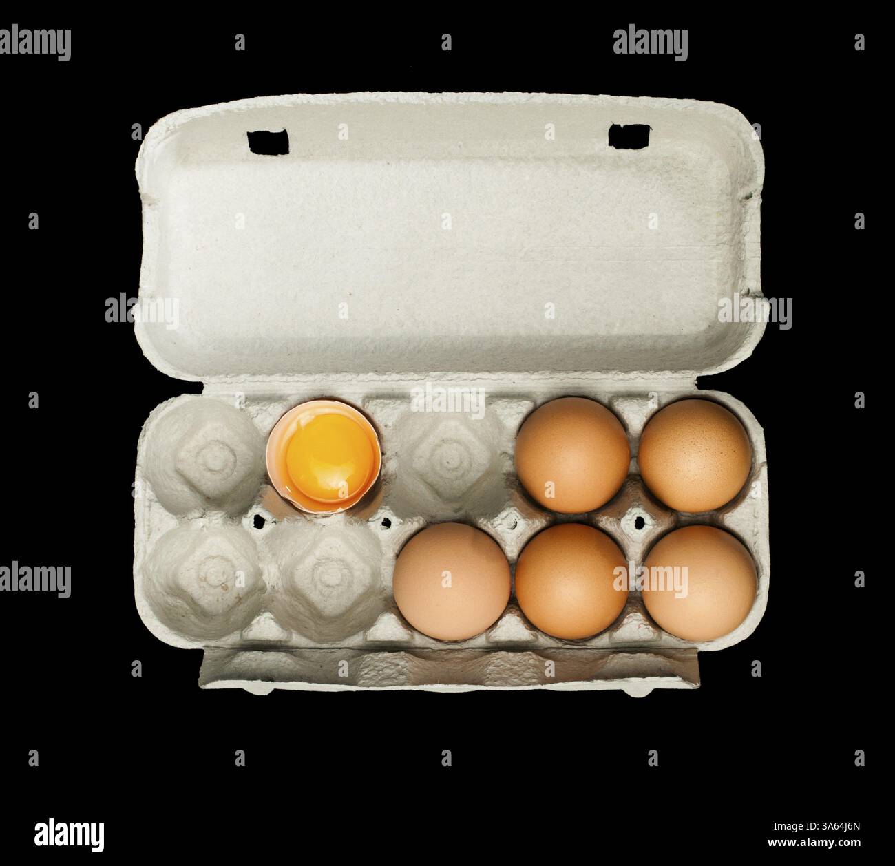 Eggs box and aggs inside. Isolated on black background.Broken egg in a carton Stock Photo