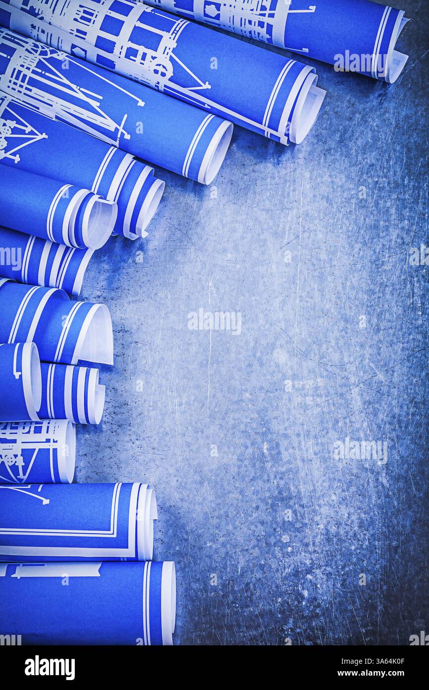Blue rolled construction plans on metallic background maintenance ...