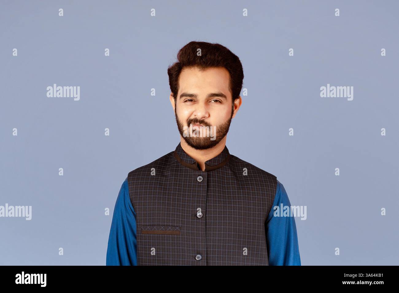 Handsome Indian guy expressing suspicion over violet background Stock Photo